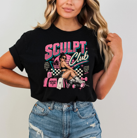 A woman wearing a black graphic t-shirt with a pink and white 'SCULPT Club' design, paired with distressed blue jeans, against a plain light gray background. Clothing, apparel and accessories for body contouring specialists and beauty professionals.