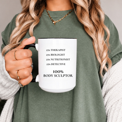 A person in an olive green shirt holds a white ceramic mug with black text that reads '25% THERAPIST 25% BIOLOGIST 25% NUTRITIONIST 25% DETECTIVE 100% BODY SCULPTOR'. Clothing, apparel, accessories and home and living for body contouring specialists and beauty professionals.