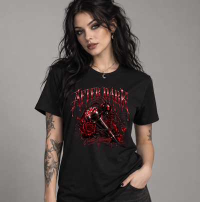 A woman modeling a black graphic t-shirt with a red and black design featuring the text 'AFTER DARK' and a bloody mallet over roses, set against a plain gray studio background. Clothing, apparel, and accessories for body contouring specialists and beauty professionals.